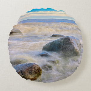 Waves crashing on shoreline rocks round cushion