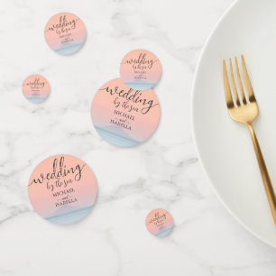 Wedding by the sea under peachy sky sunset confetti
