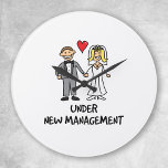 Wedding Cartoon - Under New Management Round Clock<br><div class="desc">A cute cartoon of a newlywed couple captioned 'under new management'. Is it the bride or groom that wears the trousers in the marriage? Great for a wedding gift.</div>