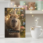 Whimsical and Funny Capybara Birthday Card<br><div class="desc">Send the most charming birthday wishes with this whimsical capybara card, perfect for anyone who appreciates quirky humour and cosy forest magic. Featuring a wide-eyed capybara in a party hat, surrounded by glowing fairy lights, fluttering butterflies, and soft mushroom tones, this design blends cute and aesthetic in the best way....</div>