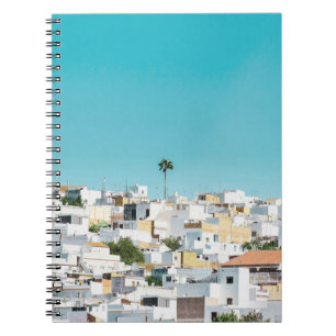 White and brown concrete houses under blue sky in notebook