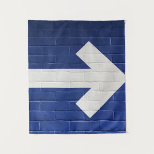 White arrow painted on brick wall tapestry