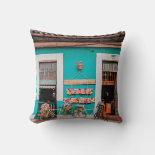 WHITE BICYCLE PARKED BESIDE TEAL PAINTED CONCRETE  CUSHION