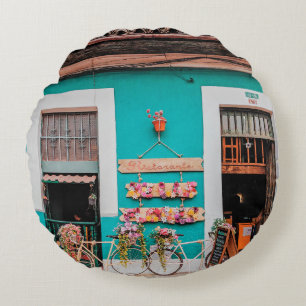 WHITE BICYCLE PARKED BESIDE TEAL PAINTED CONCRETE ROUND CUSHION