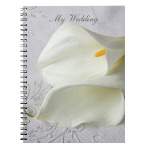 White calla lilies on linen wedding notebook