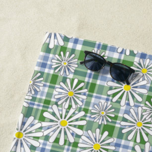 White chamomile flowers on a green blue checkered beach towel