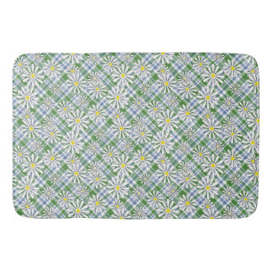 White chamomile flowers on a green blue chequered bath mat