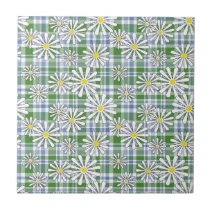 White chamomile flowers on a green blue chequered ceramic tile