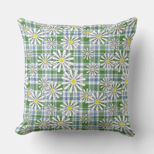 White chamomile flowers on a green blue chequered cushion