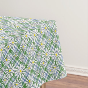 White chamomile flowers on a green blue chequered tablecloth