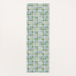 White chamomile flowers on a green blue chequered yoga mat