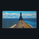 White City Lighthouse Desk Mat<br><div class="desc">A long breakwater stretches across the water towards a distant lighthouse,  drawing the eye along its weathered surface. The contrast between textured concrete,  open water,  and sky creates a strong sense of direction and depth.</div>