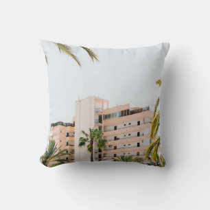 WHITE CONCRETE BUILDING BESIDE GREEN PALM TREE UND CUSHION