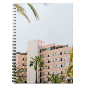 WHITE CONCRETE BUILDING BESIDE GREEN PALM TREE UND NOTEBOOK