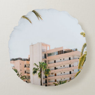 WHITE CONCRETE BUILDING BESIDE GREEN PALM TREE UND ROUND CUSHION