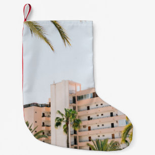 WHITE CONCRETE BUILDING BESIDE GREEN PALM TREE UND SMALL CHRISTMAS STOCKING