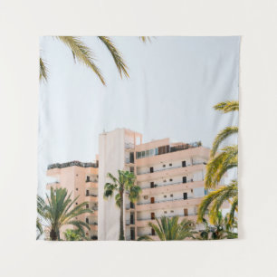 WHITE CONCRETE BUILDING BESIDE GREEN PALM TREE UND TAPESTRY