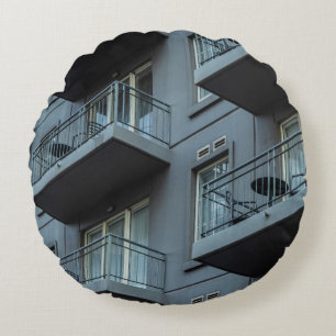 WHITE CONCRETE BUILDING WITH WHITE METAL RAILINGS ROUND CUSHION