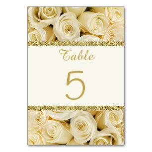 White cream roses with a gold coloured boarder table number