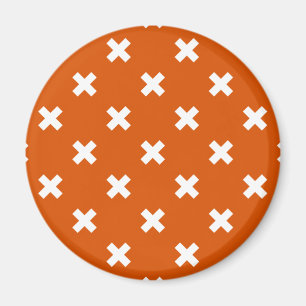 White cross stitches on burnt orange magnet