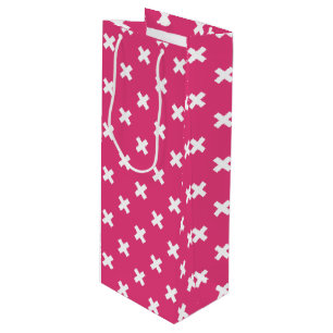 White cross stitches on fuchsia wine gift bag