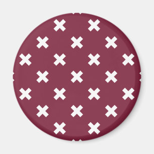 White cross stitches on mulberry magnet