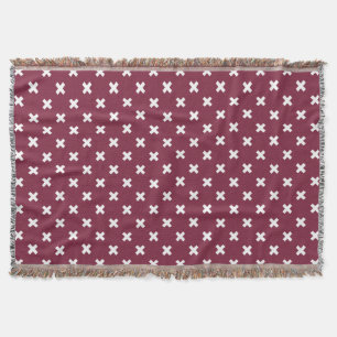 White cross stitches on mulberry throw blanket