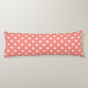 White cross stitches on peach body cushion