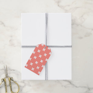 White cross stitches on peach gift tags