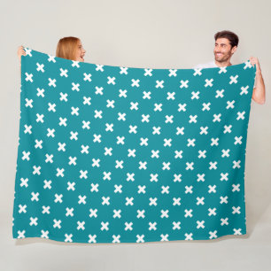 White cross stitches on teal fleece blanket