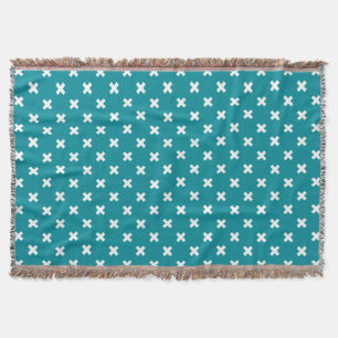 White cross stitches on teal throw blanket