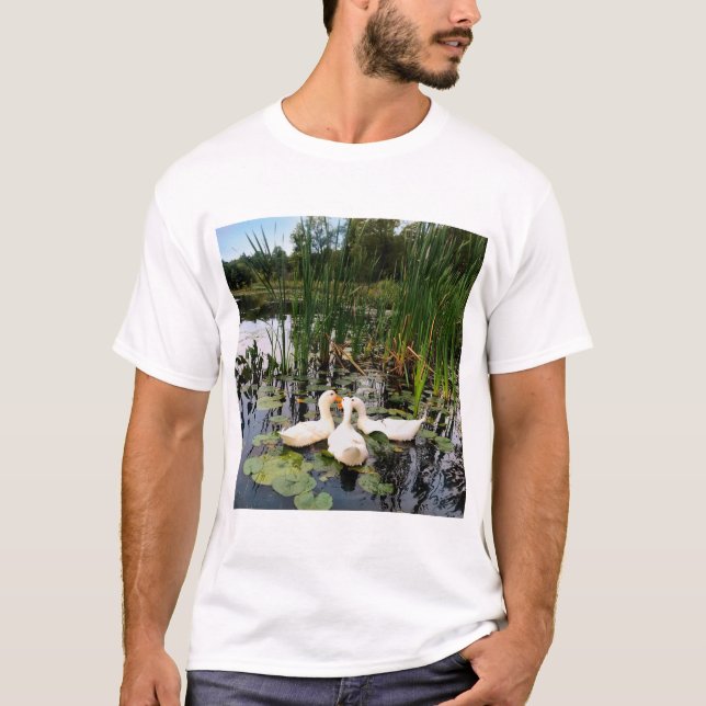 White ducks, lily pads, cattails, lake shore T-Shirt (Front)