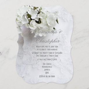 White flowers on brides dress wedding invitation