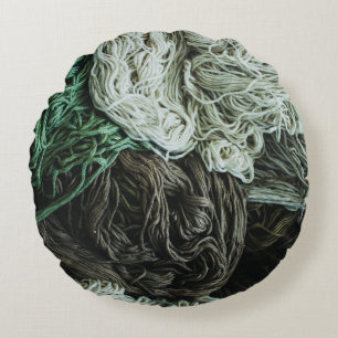White, grey, and green ropes round cushion