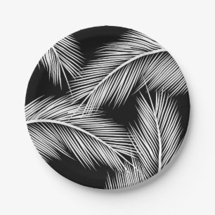 White palm leaves on black colour background paper plate