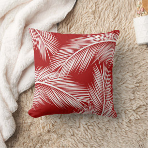 White palm leaves on red colour background cushion