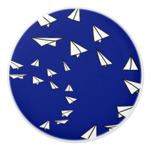 White paper planes on blue ceramic knob