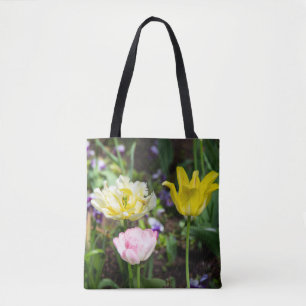 White, pink and yellow tulips in the garden     tote bag