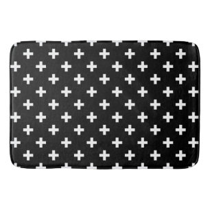 White polka crosses on black bath mat