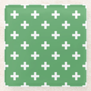 White polka crosses on green glass coaster