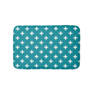 White polka crosses on teal bath mat