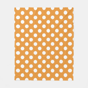 White polka dots on amber fleece blanket