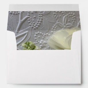 White ranunculus and lilacs on textured paper envelope
