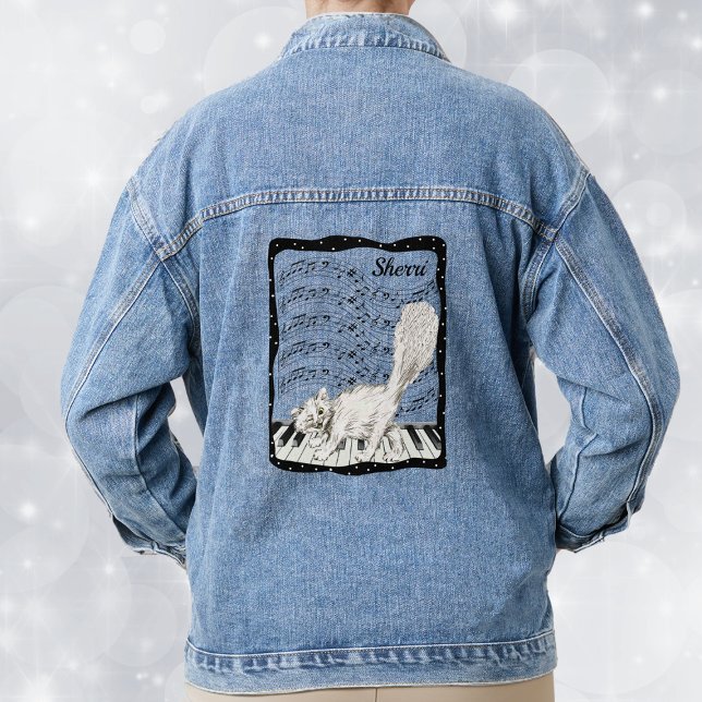 White Smiling Cat on Piano Keys Music Notes Frame Denim Jacket (Happy white cat on piano keys with bars of music notes in white dotted black frame on denim jacket.)