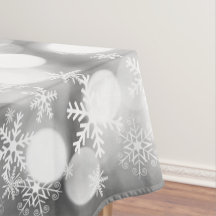 White snowflakes on grey Xmas tablecloth.