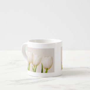 White tulips against a white background, espresso cup