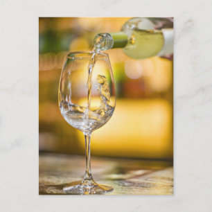White wine is poured from bottle in restaurant. postcard