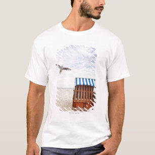 Wicker beach chair on beach T-Shirt