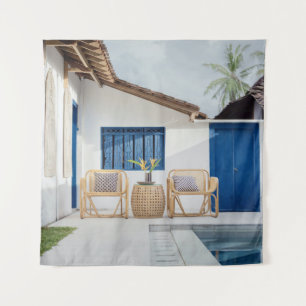 Wicker table and two chairs near swimming pool tapestry