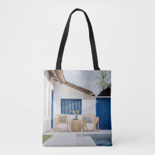 Wicker table and two chairs near swimming pool tote bag